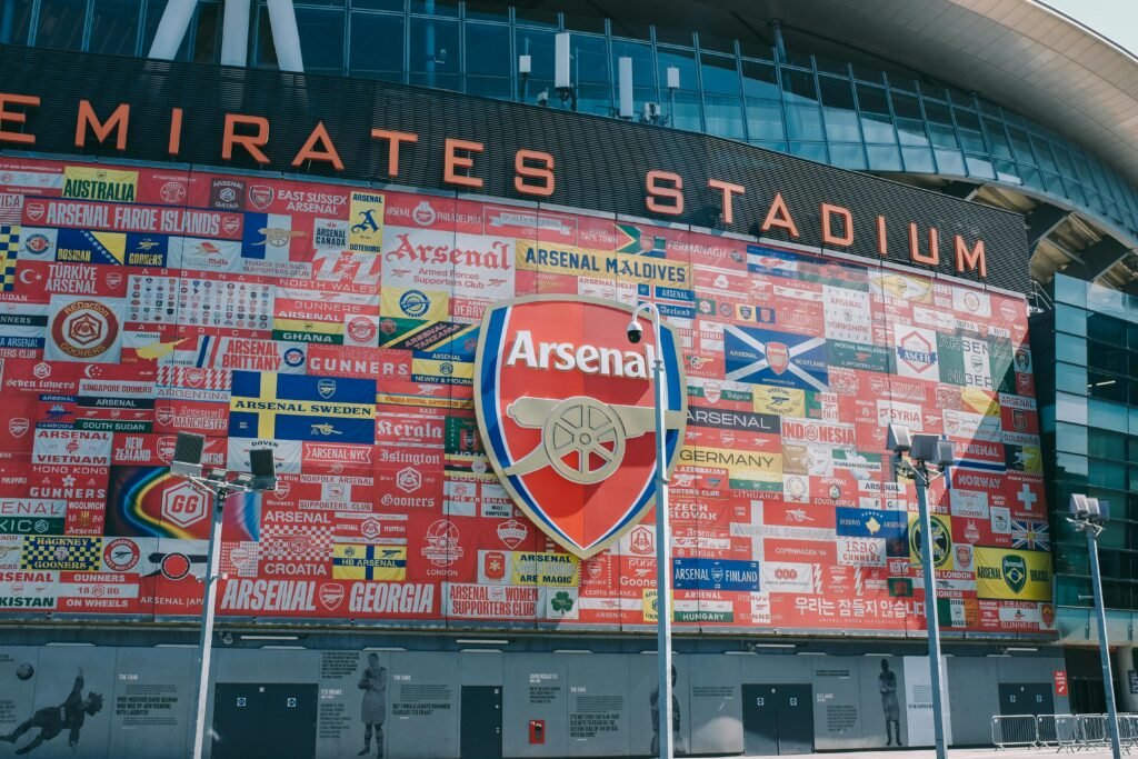 Vibrant wall art at Emirates Stadium featuring Arsenal flags and crest in London, UK.